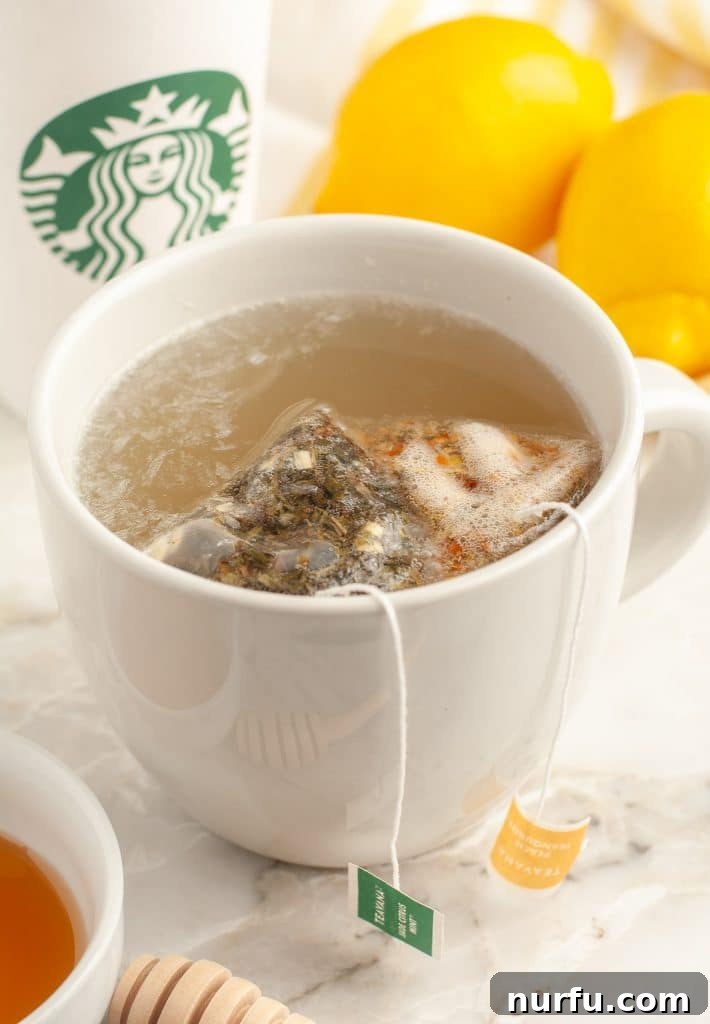 Starbucks Soothing Elixir 5 Two tea bags steeping in a glass mug of hot water, illustrating the initial step of tea preparation for Medicine Ball Tea.