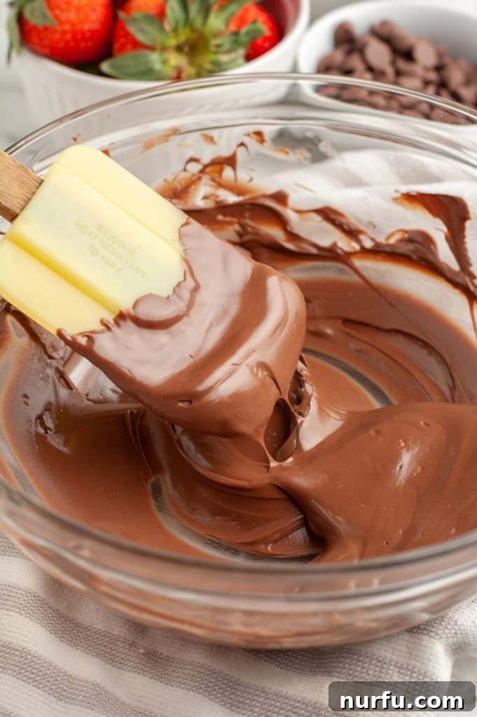 Mastering Melted Chocolate: 3 Simple Techniques 7 Bowl of melted chocolate and yellow spatula.