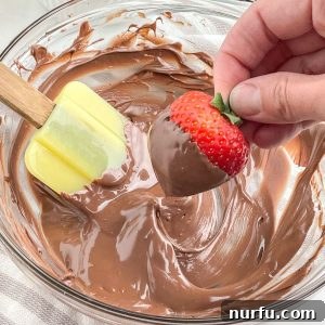Melted chocolate in a bowl with a strawberry.