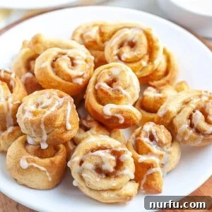 King's Cinnamon Crunch 6 Small cinnamon rolls on a plate, drizzled with white icing.