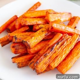 A plate of perfectly roasted air fryer carrots, showcasing their rich color and tender texture.