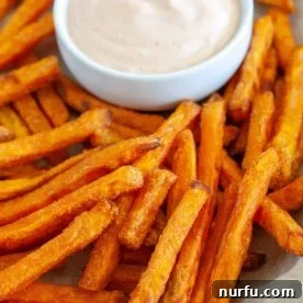 A plate of golden, crispy air-fried sweet potato fries, ready to be enjoyed.