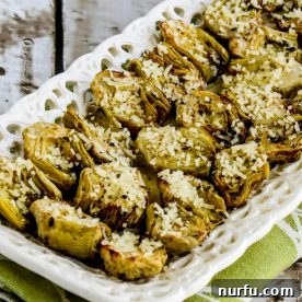 Roasted artichoke hearts on a elegant serving dish, perhaps garnished with herbs or cheese.