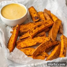 Crispy sweet potato wedges served in a basket, indicating their air-fried perfection.
