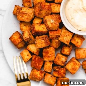 A plate of golden brown, crispy air fryer tofu pieces, ready to be enjoyed.