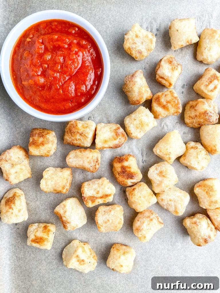 Crispy Air Fryer Cauliflower Gnocchi 6 A plate of perfectly cooked air fryer cauliflower gnocchi served with a small bowl of rich red marinara sauce.