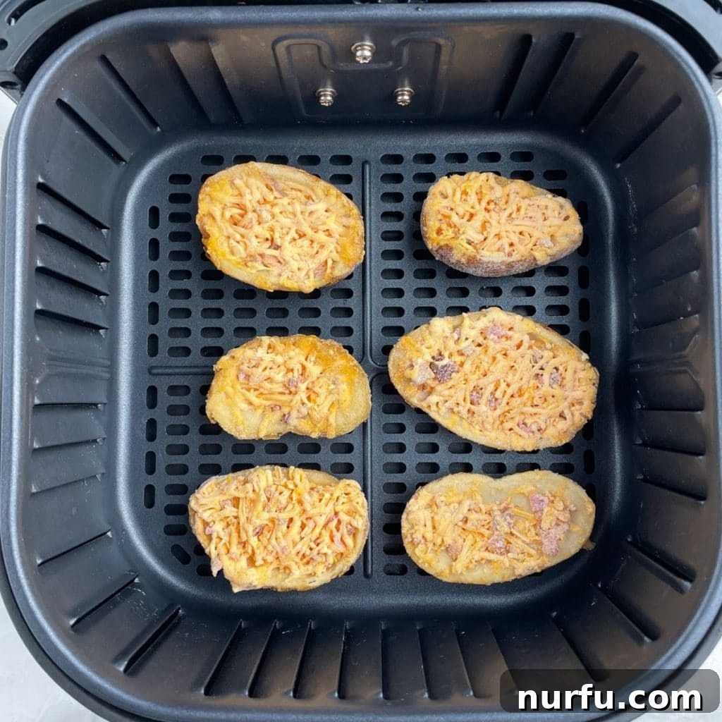 From Frozen to Fabulous: Air Fryer Potato Skins 4 An air fryer basket meticulously arranged with frozen potato skins, showcasing the essential single-layer technique for even cooking and ultimate crispiness.
