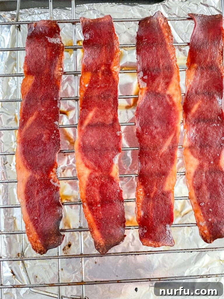 Crispy Oven Turkey Bacon 4 Perfectly cooked, golden-brown turkey bacon cooling on a wire rack after being baked in the oven.