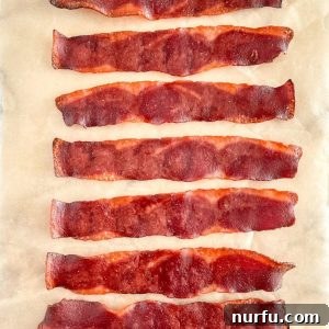 Crispy Oven Turkey Bacon 5 Cooked turkey bacon on parchment paper.