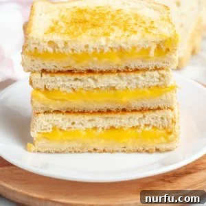 Stacked grilled cheese sandwiches on a plate.