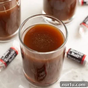 Shot glass with dark drink and Tootsie roll candy.