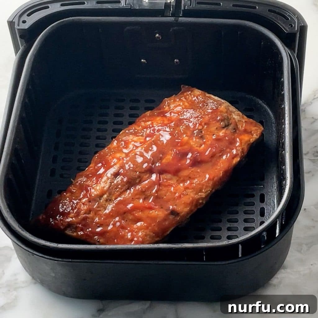 How To Reheat Ribs in Air Fryer Cooked ribs in an air fryer basket, ready to be heated to perfection.