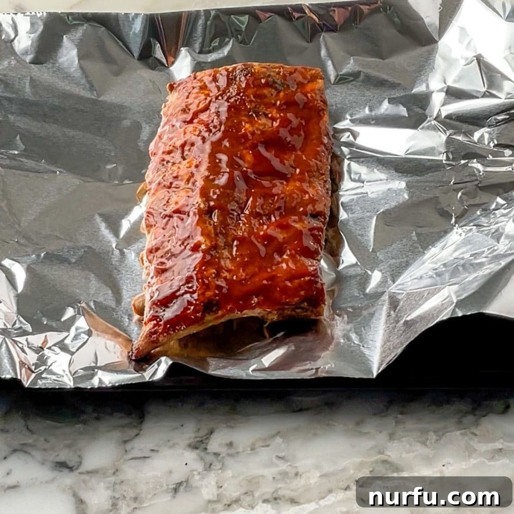 How To Reheat Ribs in Oven Cooked ribs wrapped in foil, ready to be reheated in the oven.
