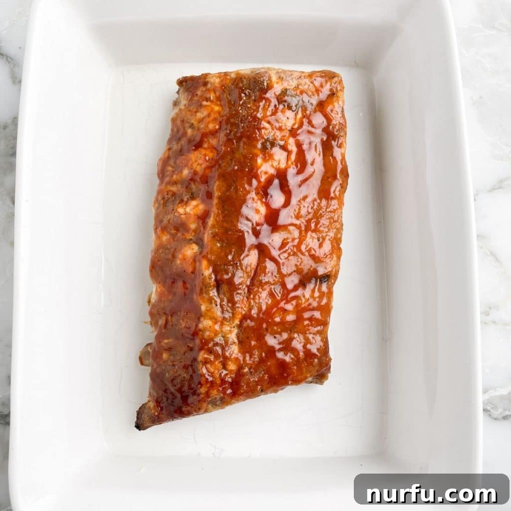 How To Reheat Ribs in Microwave Rack of ribs in a casserole dish, suitable for microwave reheating with added moisture.