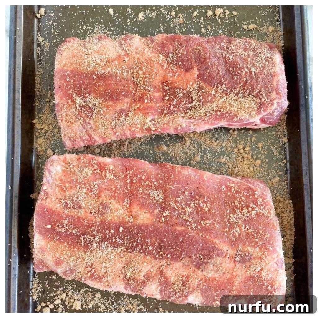 Fall-Off-The-Bone Oven Ribs 5 An uncooked rack of baby back ribs, completely covered and seasoned with the rich homemade spice rub.