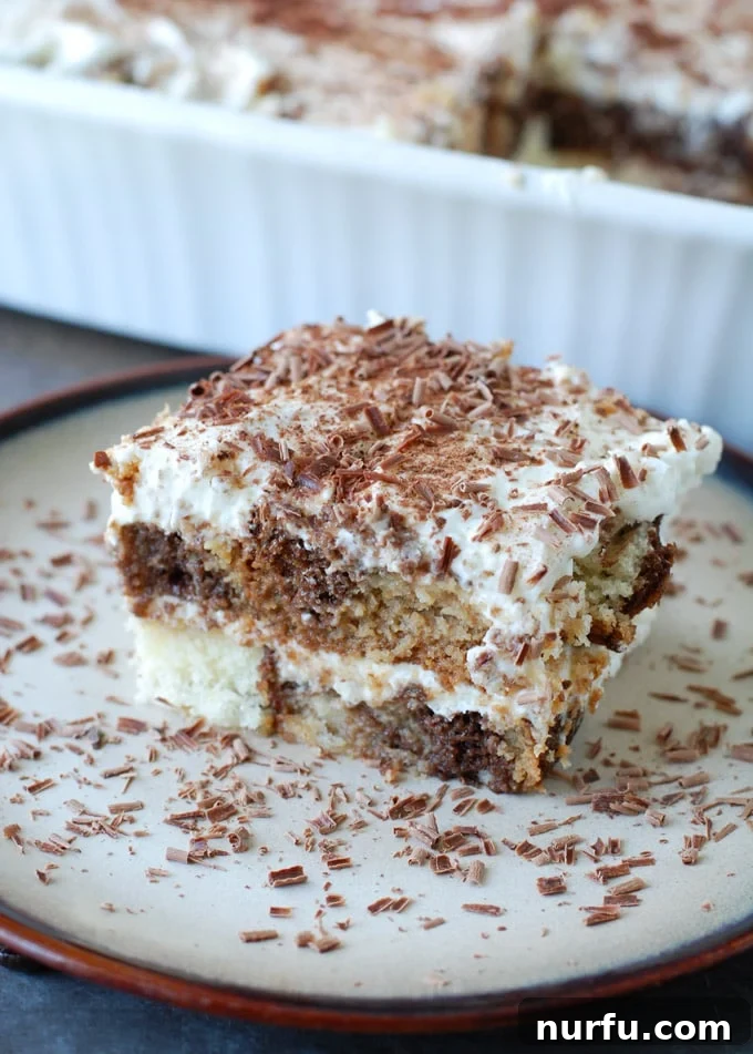 Pound Cake Tiramisu Slice A slice of chocolate and vanilla tiramisu made with pound cake, served on a white plate with a fork, showing its distinct creamy and coffee-soaked layers.