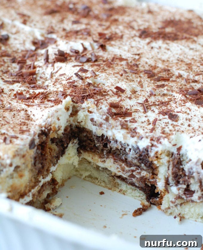 Easy Pound Cake Tiramisu Layers A close-up shot of easy tiramisu made with pound cake in a glass dish, showing the beautiful layers of cream, cake, and chocolate, ready to be chilled.