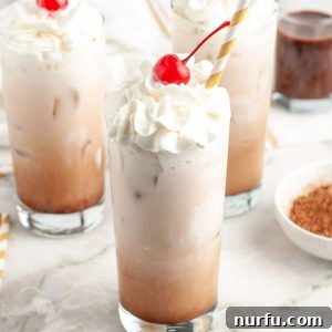 Velvet Chocolate Cream Soda 6 Tall glass with creamy drink and a cherry on top.