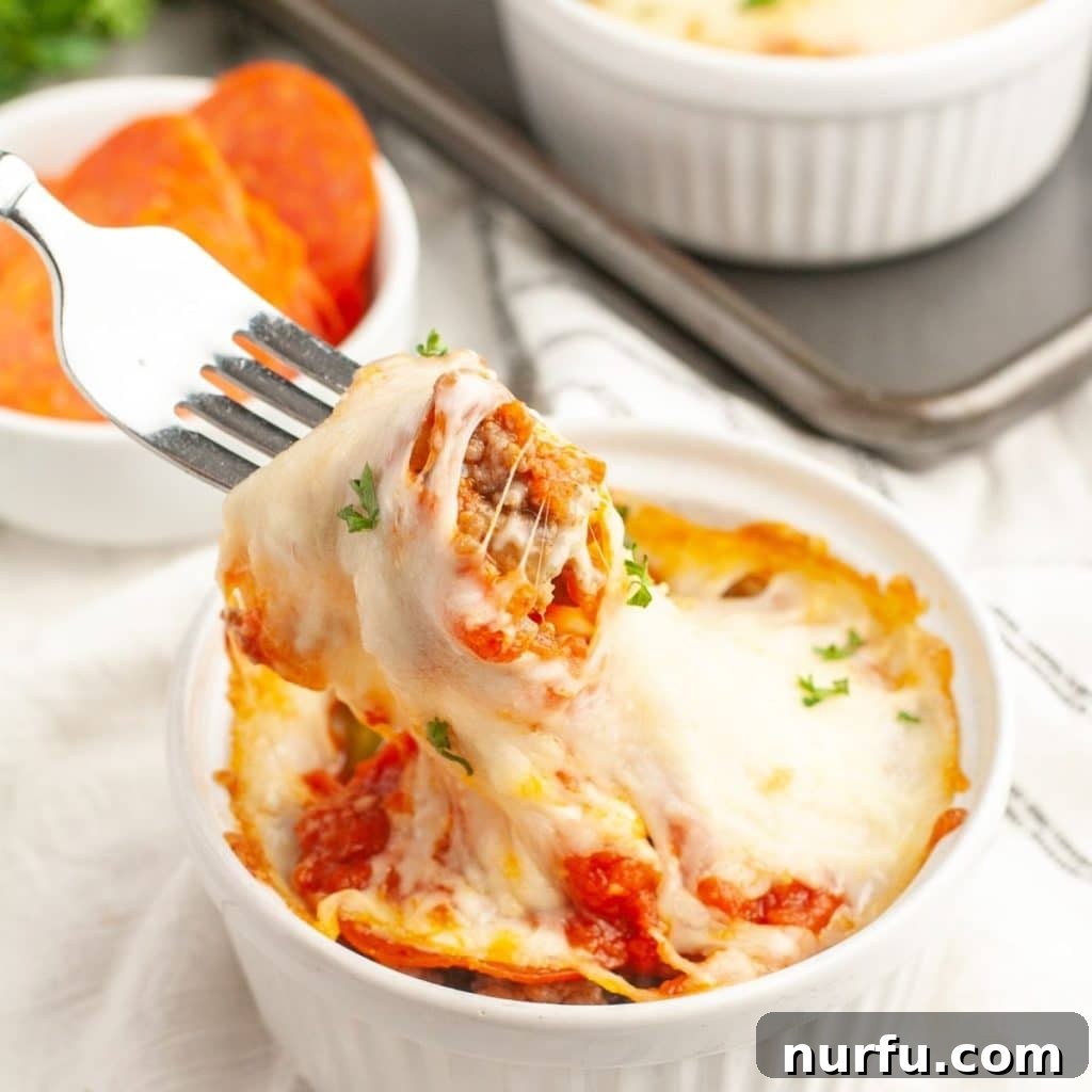 Ultimate Easy Pizza Bowl 2 Fork picking up sausage and melted cheese from a pizza bowl, showcasing the delicious, gooey texture.