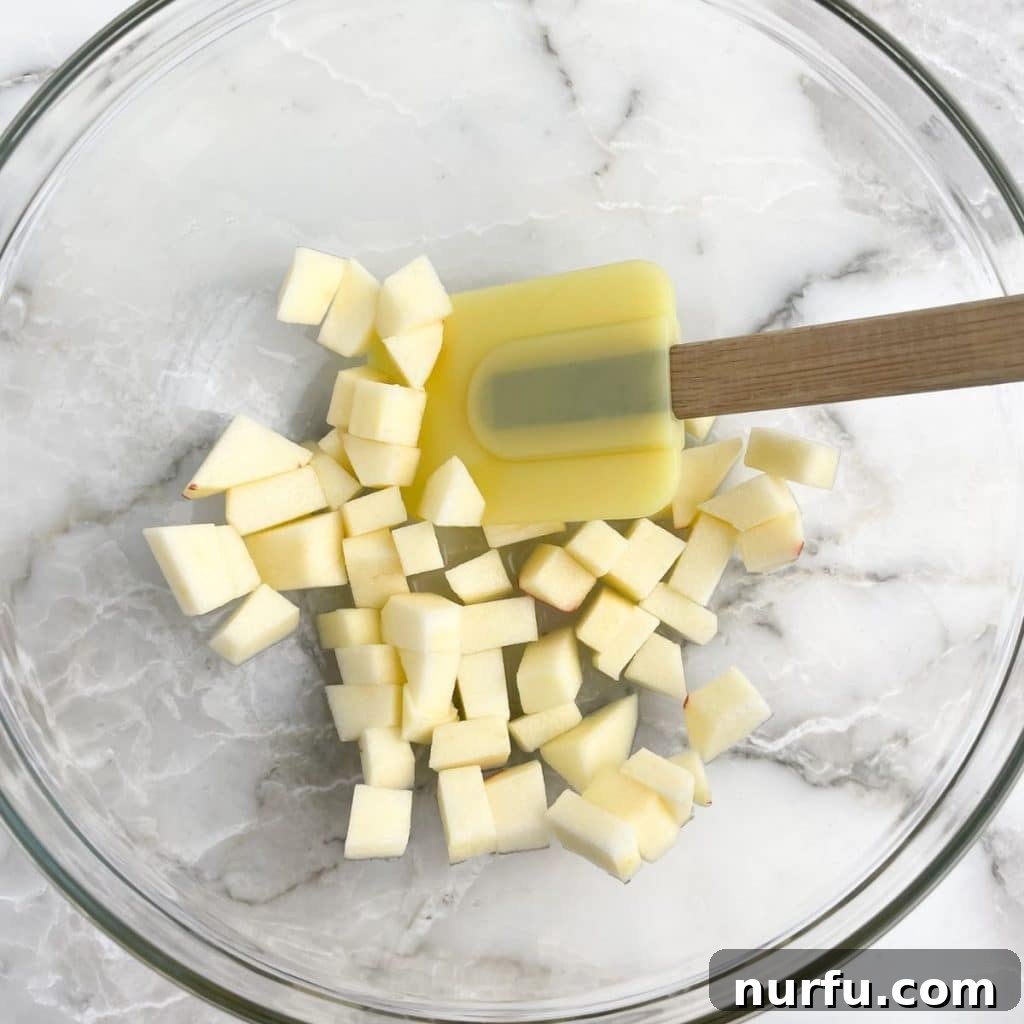 Arby's Style Homestyle Chicken Salad 4 Diced apples in a bowl with a spatula.