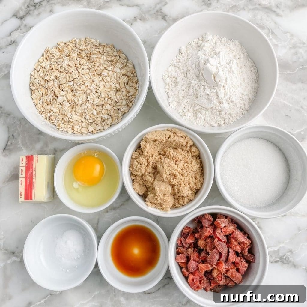 Strawberry Oat Delight Cookies 3 Various baking ingredients in separate bowls: old-fashioned oats, all-purpose flour, granulated sugar, light brown sugar, dried strawberries, softened butter, and an egg.