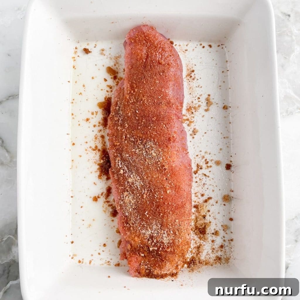 Mastering Pork Tenderloin: 400F Oven Cook Time Guide 4 Uncooked pork tenderloin seasoned with spices in a baking dish.
