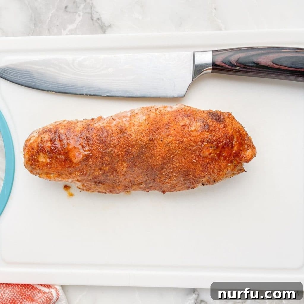 Mastering Pork Tenderloin: 400F Oven Cook Time Guide 5 Cooked, golden-brown pork tenderloin resting on a cutting board.
