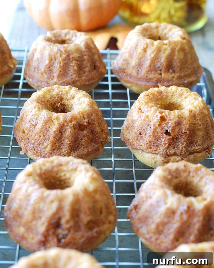 Close-up shot of a single pumpkin bundt cake, showing its perfectly piped buttercream and scattered toffee pieces, tempting the viewer.