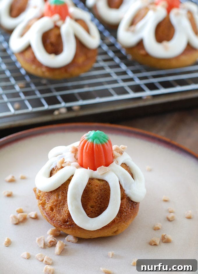 An inviting display of pumpkin toffee mini bundt cakes, beautifully frosted and decorated, symbolizing the deliciousness and warmth of fall.