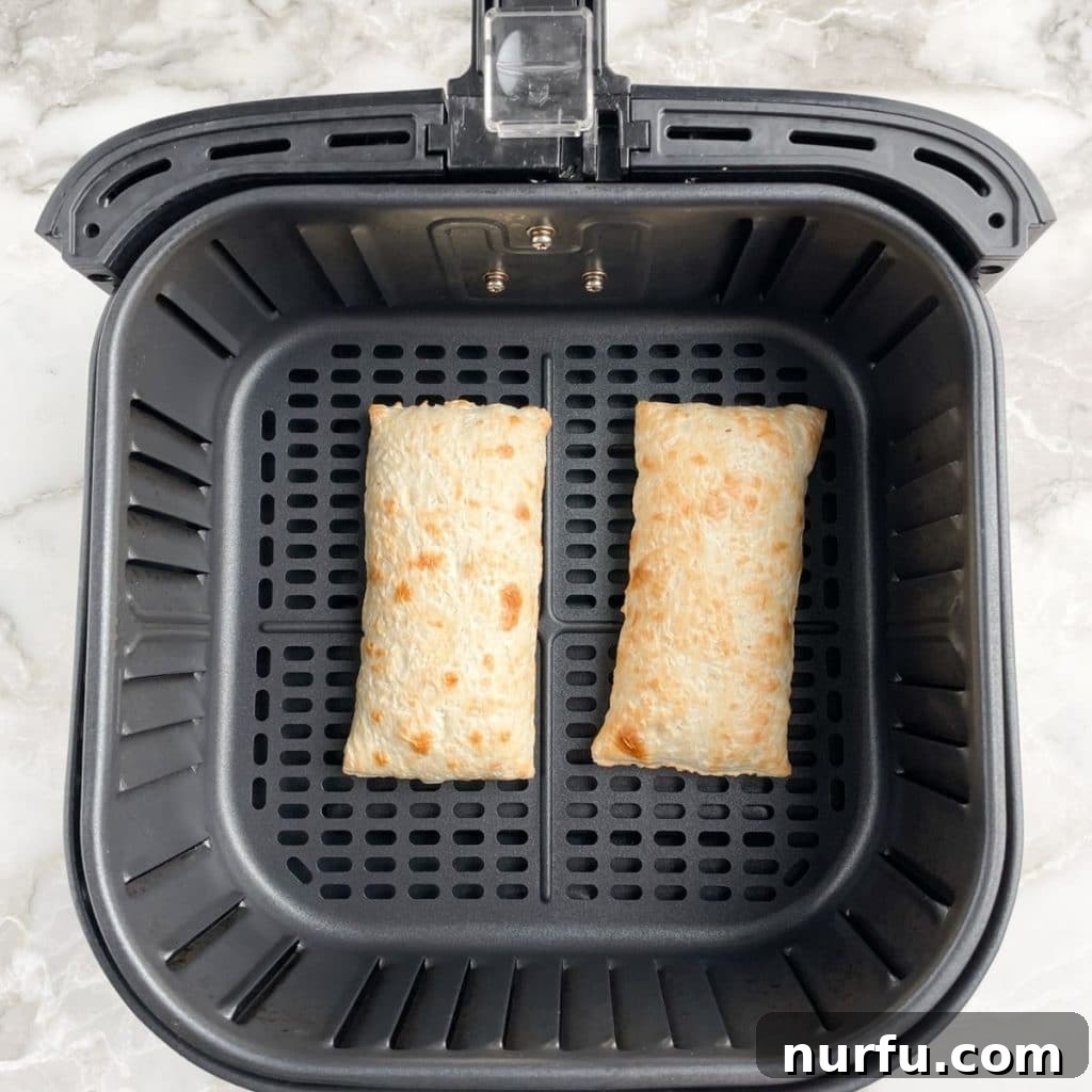 Crispy Air Fryer Hot Pockets 3 Two frozen Hot Pockets placed in a single layer inside an air fryer basket, ready for cooking.