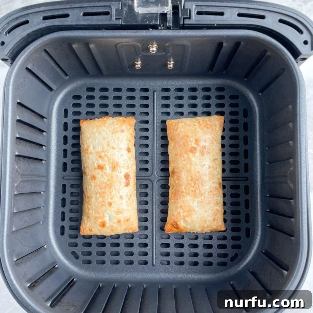 Crispy Air Fryer Hot Pockets 4 Three golden-brown, cooked Hot Pockets resting in an air fryer basket after cooking.