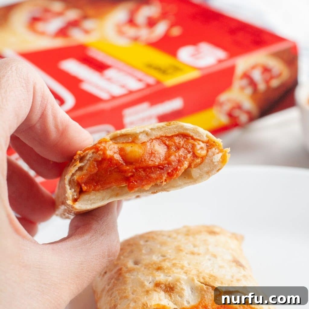 Crispy Air Fryer Hot Pockets 5 A hand holding a perfectly cooked, golden-brown Hot Pocket, showcasing its crispy texture.