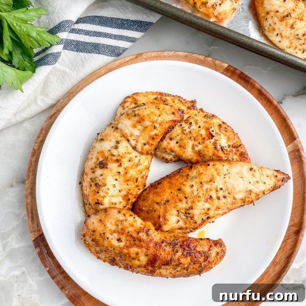 Cooked chicken tenders perfectly arranged on a white plate, ready for serving.