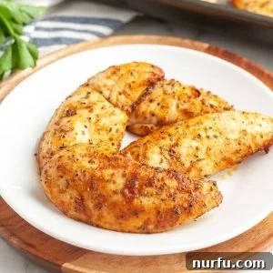 Plate of cooked chicken tenders, golden-brown and garnished.