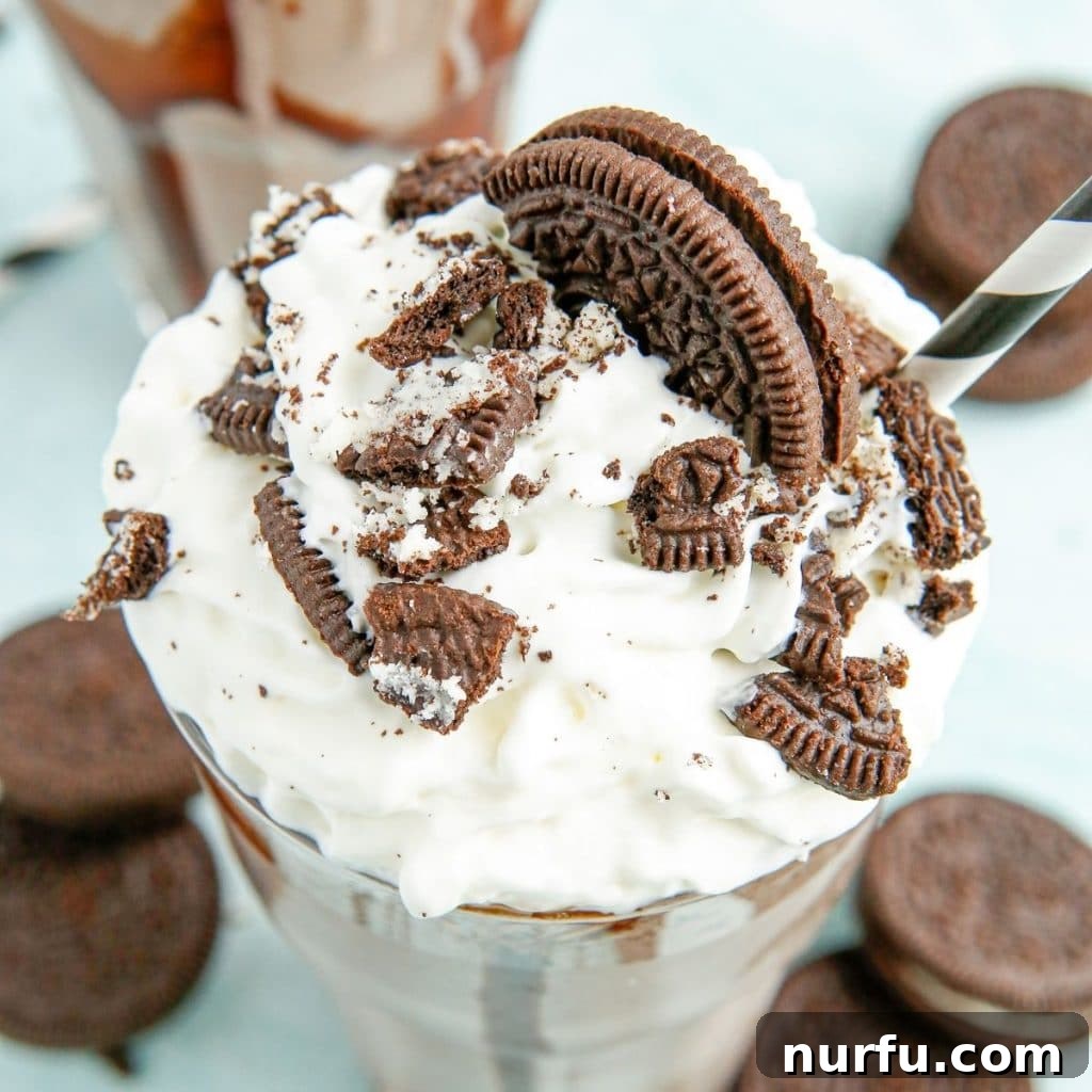 A beautifully presented OREO milkshake, topped with a swirl of whipped cream and crushed OREO cookie pieces, ready to be enjoyed.