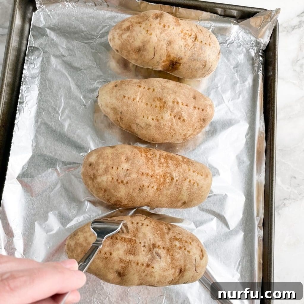 Optimal Potato Bake Time at 400 4 Potatoes on a baking sheet with fork.