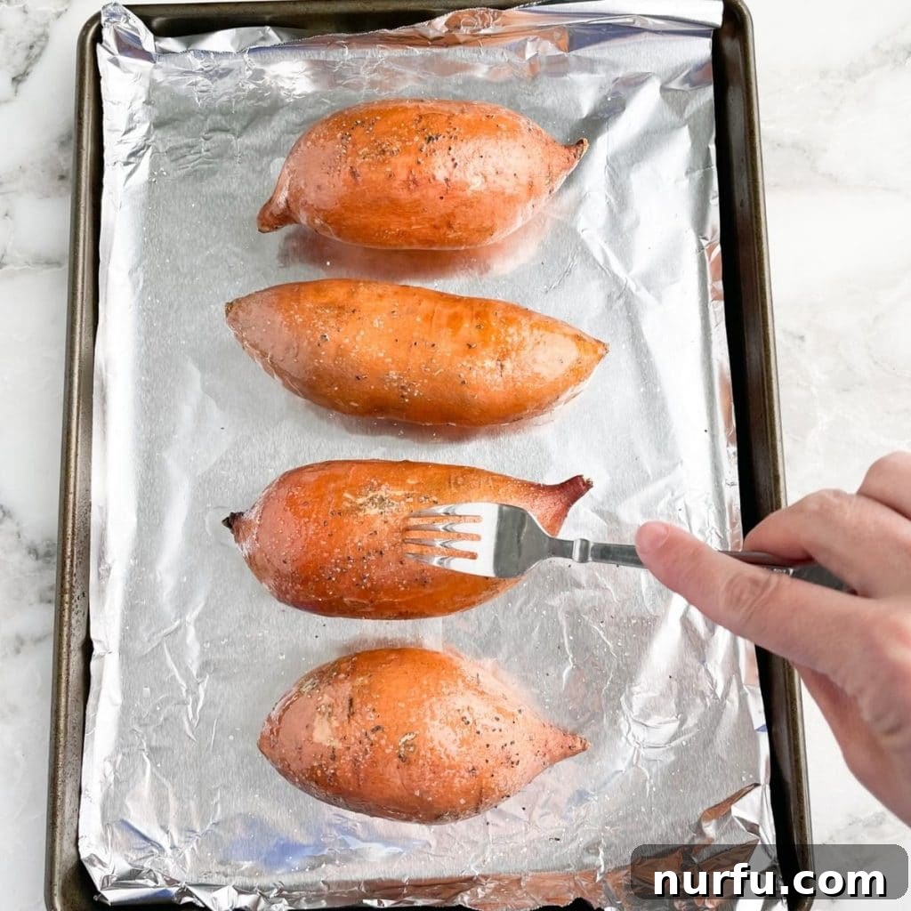 Mastering 400 Degree Sweet Potatoes Bake Time Revealed 5 A fork testing the tenderness of a baked sweet potato inside a hot oven, indicating it's nearly done.