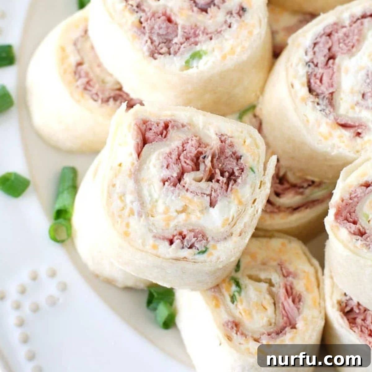 50 Refreshing Cold Lunch Ideas 13 A plate of savory roast beef tortilla roll-ups, sliced into bite-sized pieces for an easy lunch.