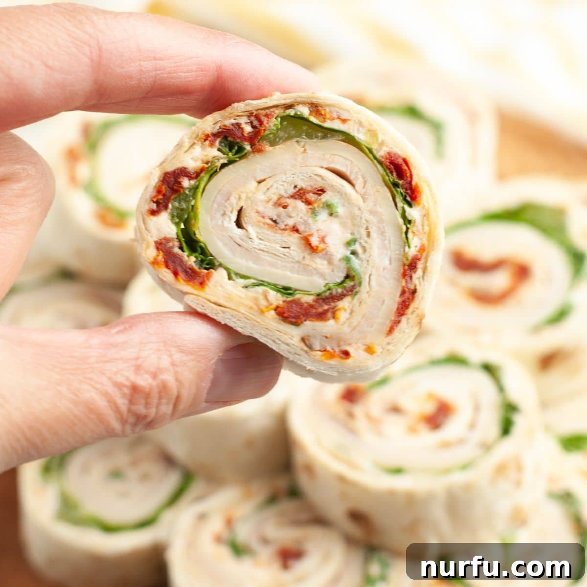 50 Refreshing Cold Lunch Ideas 14 A hand holding a turkey roll-up, demonstrating a quick and flavorful cold lunch idea.