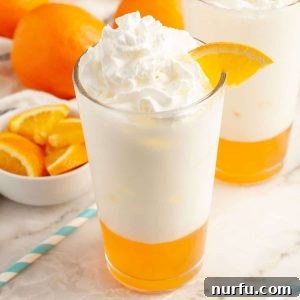 Glass of orange cream soda with orange slice.