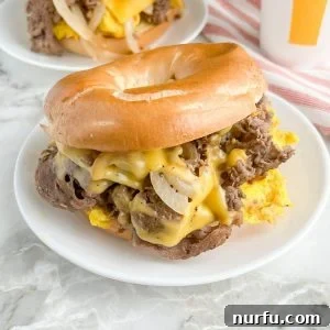 A perfectly assembled homemade Steak, Egg, and Cheese Bagel sandwich on a rustic plate, ready to be enjoyed.