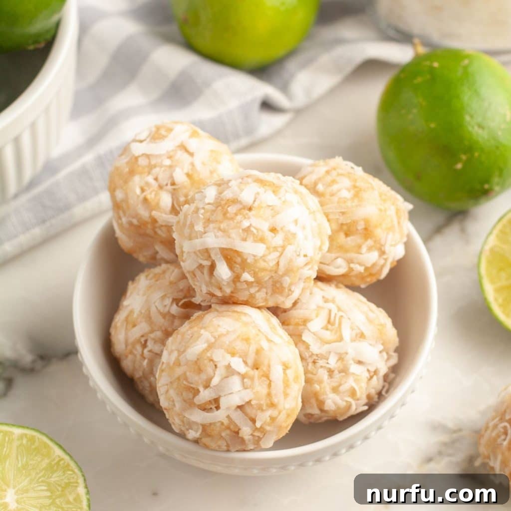 Zesty Coconut Lime Bites 2 A bowl brimming with perfectly rounded lime coconut balls, with fresh limes artfully placed beside it.