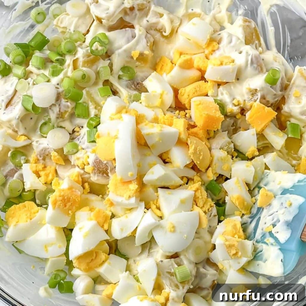 Boiling Potatoes for Perfect Potato Salad 6 A large bowl of finished potato salad, perfectly chilled and ready to serve, showing creamy texture and visible ingredients.