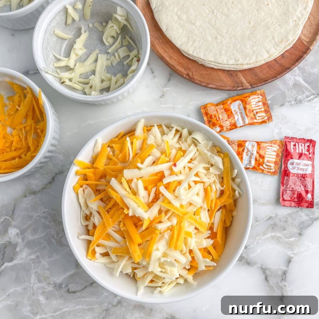 Homemade Gooey Cheese Tortilla Rolls 3 A bowl of freshly shredded cheese sits beside a single flour tortilla on a plate, ready for assembly.