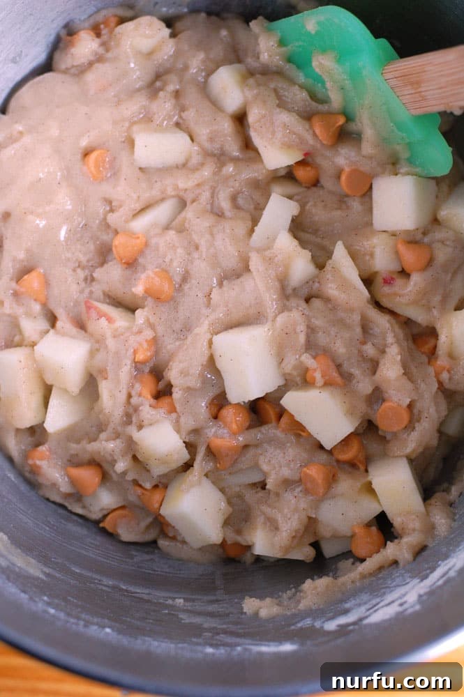 Apple cake mixture Close-up of the apple dessert batter, showcasing chunks of fresh apple and scattering of butterscotch chips.