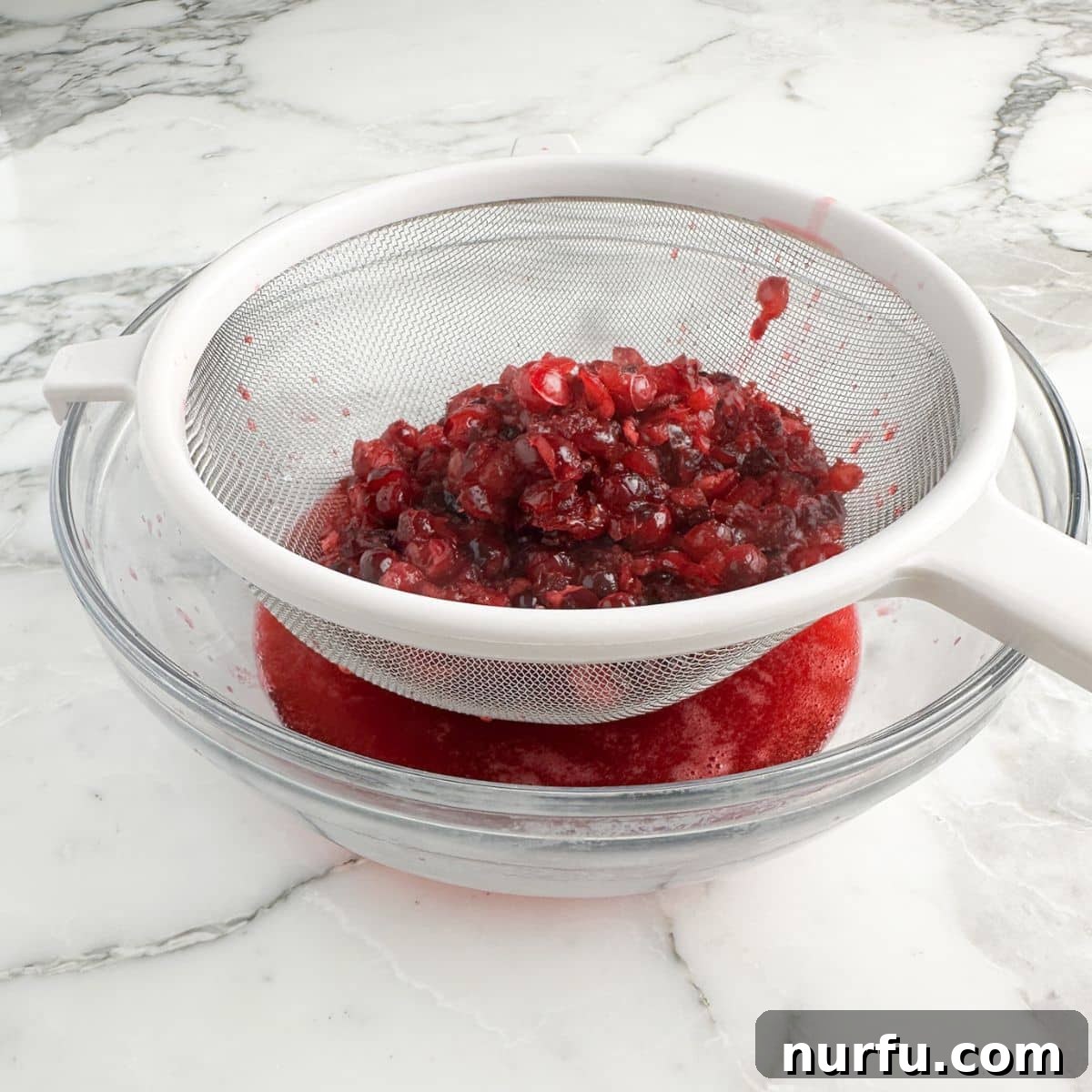 Crimson Citrus Sparkle 5 Strainer with cranberries and cranberry juice.