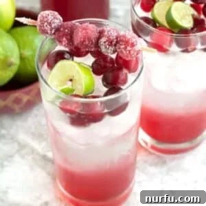 Crimson Citrus Sparkle 9 Glass of cranberry mocktail with sugared cranberries and lime.