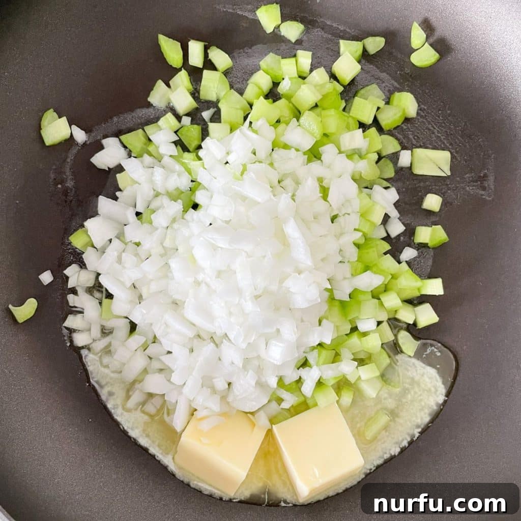 Crispy Oven Baked Stove Top Stuffing 4 A skillet on the stove top contains melting butter with finely diced onion and celery, beginning to soften.