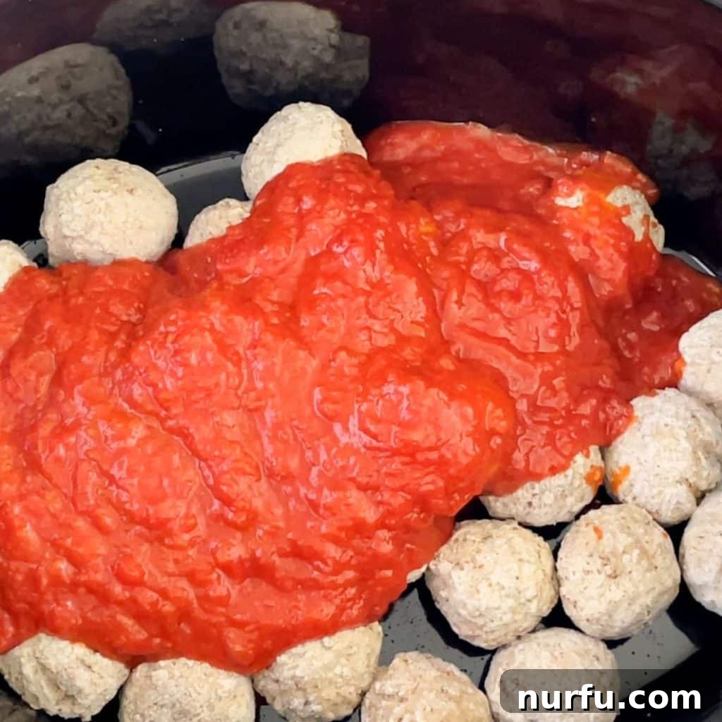 Crockpot Frozen Meatballs: Your Guide to Perfect Timing 4 Slow cooker with frozen meatballs and red sauce.