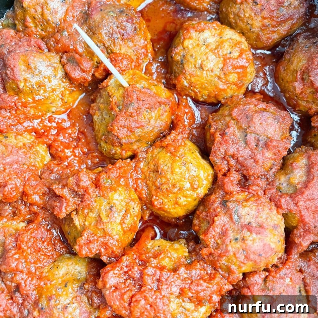 Crockpot Frozen Meatballs: Your Guide to Perfect Timing 6 Meatballs in sauce with a toothpick.